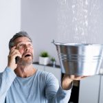 Man catching water from Leaking Pipes.