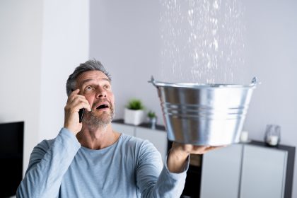 Man catching water from Leaking Pipes.