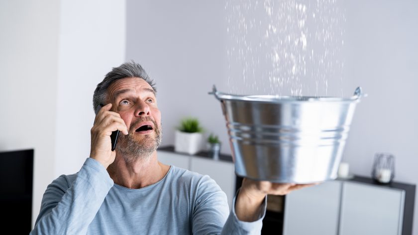 Man catching water from Leaking Pipes.