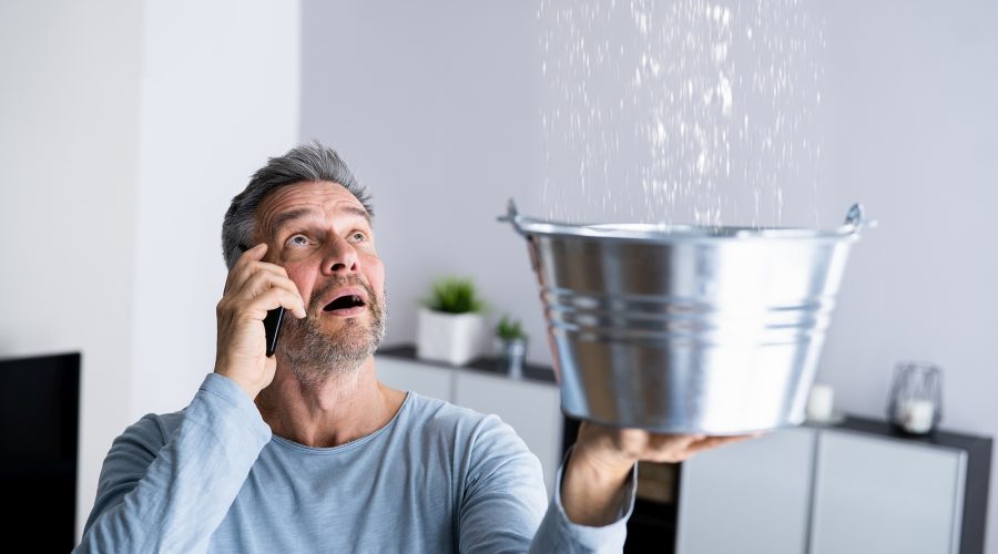 Man catching water from Leaking Pipes.